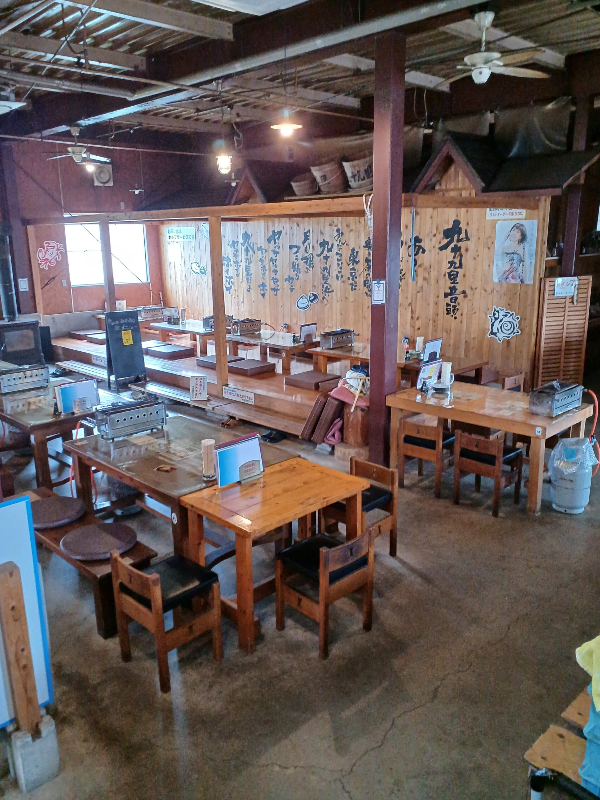 ばんや 店内 七輪付きテーブルが並ぶ漁師小屋風の広い空間