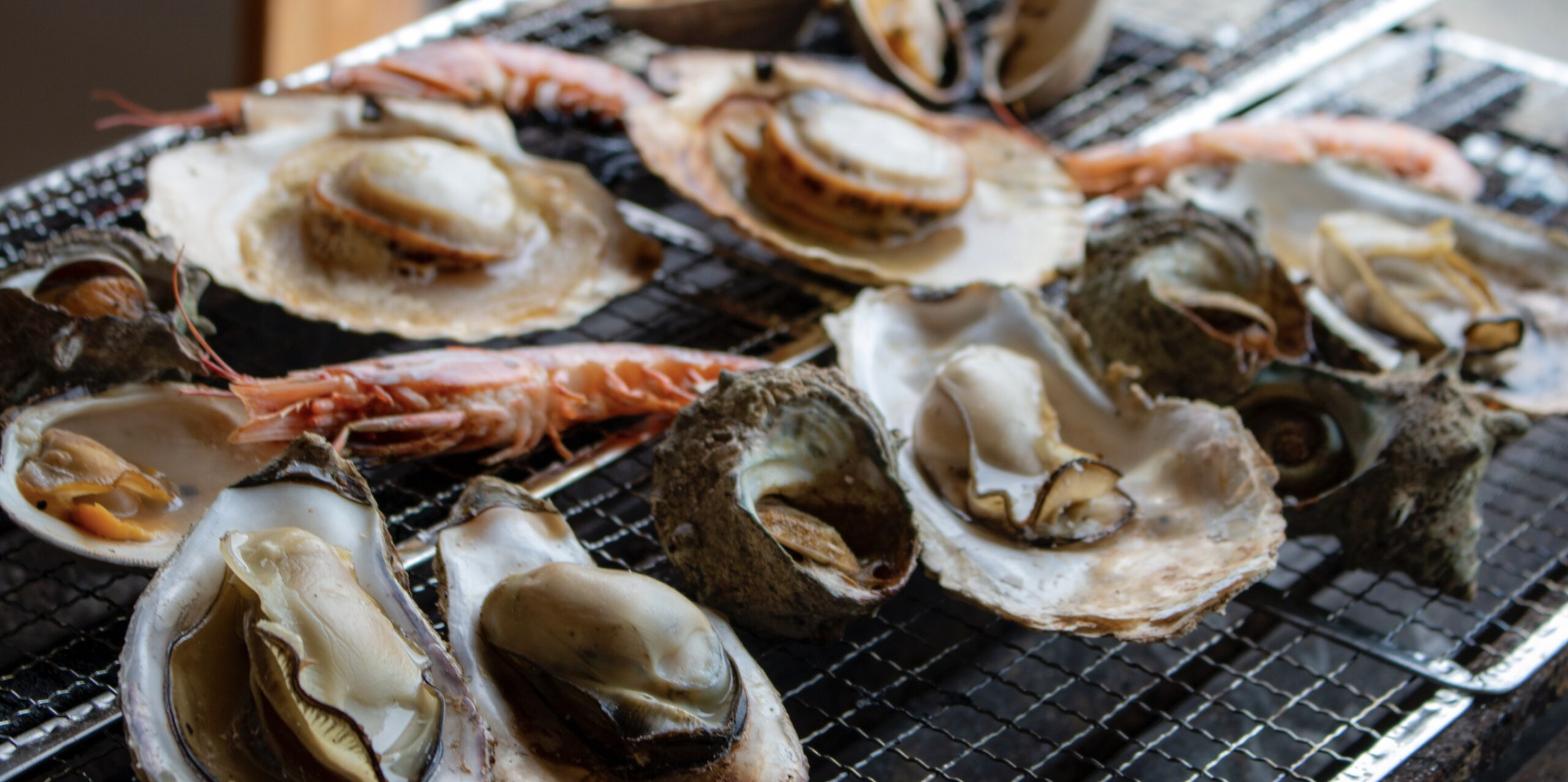 海鮮浜焼き まるはまの網で焼く牡蠣・ホタテ・サザエ